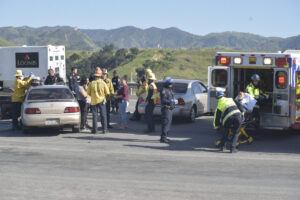 Emergency personnel gather around two vehicles to assist the injured drivers after a Highway 126 crash.